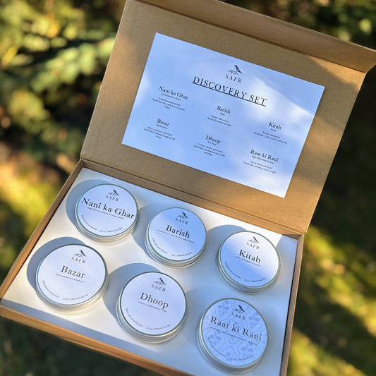 Open discovery set with six small tins and a label on a natural background